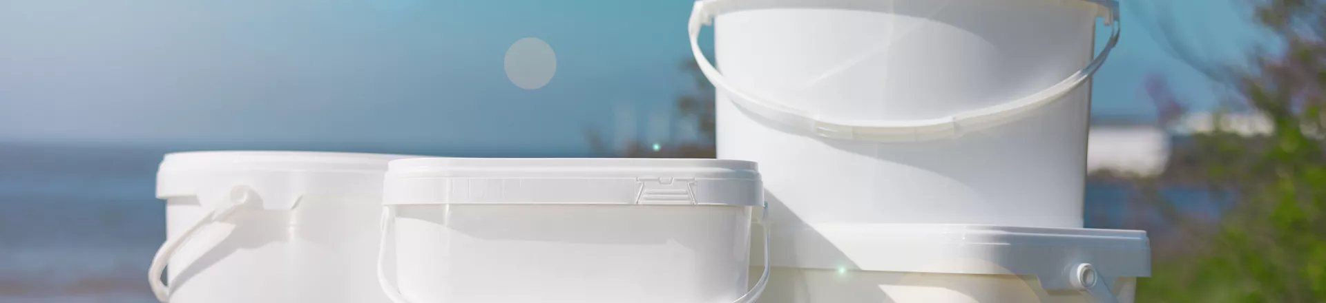 Vita plasthinkar med lock med blå bakgrund