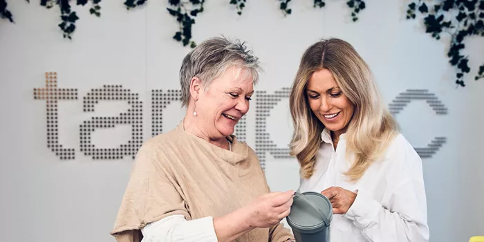 Kollegor diskuterar återvunnen plastburk